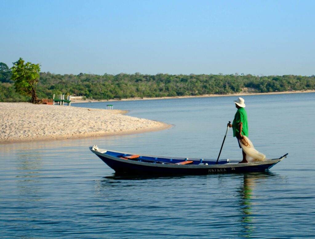 A fisherman in a canoe on a serene river near Alter do Chão, Brazil.