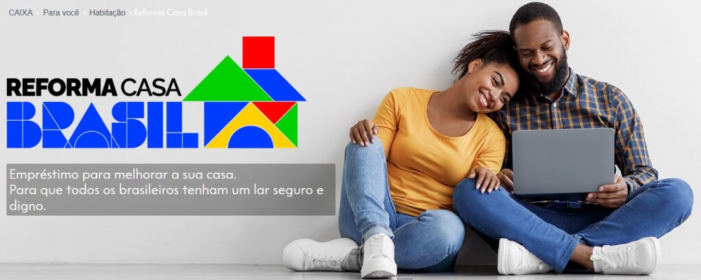 Reforma Casa Brasil Casal feliz sentado em frente ao notebook simulando como solicitar o empréstimo